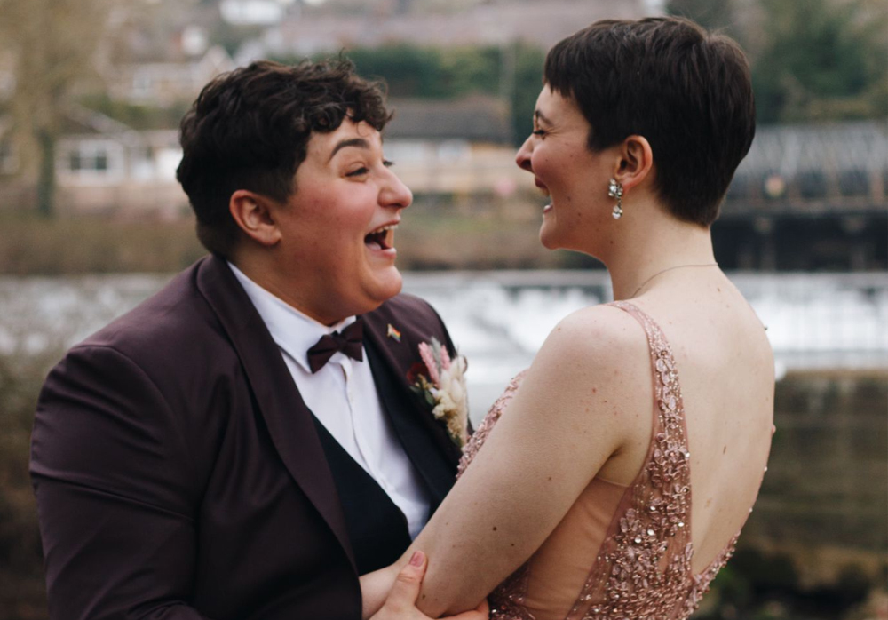 Two woman laughing at their wedding