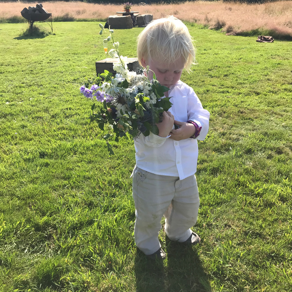 Young boy holding flowers.